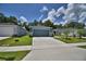 Single-story home with a well-maintained lawn and driveway leading to the attached two-car garage at 312 Walnut Ln, Auburndale, FL 33823