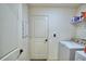 Functional laundry area featuring a washing machine and storage shelves at 312 Walnut Ln, Auburndale, FL 33823