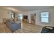 Spacious living room with hardwood floors, a grey sofa, and a view into dining area at 312 Walnut Ln, Auburndale, FL 33823