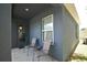 Covered patio features neutral colored siding, two chairs, and an exterior door and window at 312 Walnut Ln, Auburndale, FL 33823