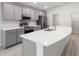 Modern kitchen with sleek gray cabinets, quartz countertops, and stainless steel appliances at 3135 Laurel Oak Ln, Winter Haven, FL 33884