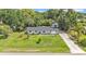 This stunning home features a well-manicured lawn, long driveway, and lush mature landscaping at 3235 Sandpiper Ln, Mulberry, FL 33860