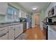 Well-lit kitchen featuring white cabinetry, stainless steel appliances, and wood flooring at 3783 Wildcat Run, Lakeland, FL 33810