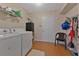 This laundry room features a washer and dryer, along with storage space and cleaning supplies at 3783 Wildcat Run, Lakeland, FL 33810