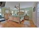 Comfortable main bedroom with a four-poster bed, wood floors, and ample natural light at 3783 Wildcat Run, Lakeland, FL 33810