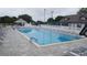 This in-ground swimming pool features plenty of lounge chairs, a fence, and shade trees nearby at 3783 Wildcat Run, Lakeland, FL 33810