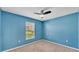 Cozy bedroom features a ceiling fan, neutral carpet, and a window letting in natural light at 3787 Sandhill Crane Dr, Lakeland, FL 33811