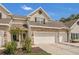 Charming townhouse featuring stone accents, attached garages and well maintained landscaping under a bright blue sky at 4309 Shipp Ct, Lakeland, FL 33813