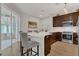 Modern kitchen with stainless steel appliances, dark wood cabinets, breakfast bar and adjacent screened in patio at 4309 Shipp Ct, Lakeland, FL 33813