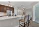 Modern kitchen with stainless steel appliances, dark wood cabinets, breakfast bar, pendant lighting and adjacent living room at 4309 Shipp Ct, Lakeland, FL 33813