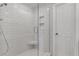 Modern shower with white subway tiles, glass door, and built-in niche and seat at 4309 Shipp Ct, Lakeland, FL 33813