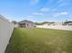 Spacious backyard featuring a white fence, play structure, lush grass, and room for outdoor activities at 4340 Reding Way, Lakeland, FL 33813