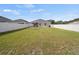 A large backyard offers a white fence for privacy, green grass, and a colorful play structure at 4340 Reding Way, Lakeland, FL 33813