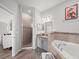 Spa-like bathroom featuring dual vanities, a soaking tub, and a glass-enclosed shower at 4340 Reding Way, Lakeland, FL 33813