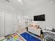 bedroom with TV, adjacent bathroom, and closet on hardwood floor for comfortable and convenient living at 4340 Reding Way, Lakeland, FL 33813