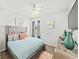 Bright bedroom featuring a tufted headboard, hardwood floors, ceiling fan, and modern decor for relaxation at 4340 Reding Way, Lakeland, FL 33813
