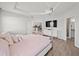 Spacious main bedroom with a TV, hardwood floors, and a view of the kitchen and ensuite bathroom at 4340 Reding Way, Lakeland, FL 33813