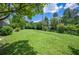 A spacious backyard with a lush lawn, framed by mature trees and greenery, offering privacy at 4908 S Bedford Ln, Lakeland, FL 33813
