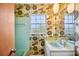 Bathroom featuring colorful floral wallpaper, tile, and a window for natural light at 4908 S Bedford Ln, Lakeland, FL 33813