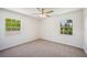 Bedroom featuring plush carpeting, a ceiling fan, and large windows with natural views at 4908 S Bedford Ln, Lakeland, FL 33813