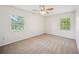 Bright bedroom featuring plush carpeting, a ceiling fan, and views from the double windows at 4908 S Bedford Ln, Lakeland, FL 33813