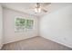 Bright bedroom with carpet floors, a ceiling fan, and a window offering natural light at 4908 S Bedford Ln, Lakeland, FL 33813