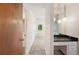 Hallway leading to a bedroom and bathroom with chandelier lighting and a marble-topped vanity at 4908 S Bedford Ln, Lakeland, FL 33813