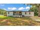 Single story house with a covered porch in front of a green lawn and mature trees at 4931 Dove Cross Dr, Lakeland, FL 33810