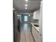 A bright kitchen with stainless steel refrigerator, white cabinets and grey vinyl flooring throughout at 526 & 528 2Nd Sw St, Fort Meade, FL 33841
