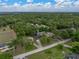 Scenic aerial view of home in a lush, green, wooded community with lake view at 5522 1St Se St, Lakeland, FL 33812