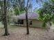 Backyard with mature trees, some covered in Spanish moss, and a screened in porch at 5522 1St Se St, Lakeland, FL 33812