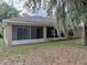 Exterior view of the home showcasing the screened patio and lush backyard with mature trees at 5522 1St Se St, Lakeland, FL 33812