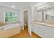 Well-lit bathroom featuring a soaking tub, toilet room, and a vanity at 5522 1St Se St, Lakeland, FL 33812