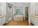 Well-lit bathroom with a soaking tub and a separate toilet room at 5522 1St Se St, Lakeland, FL 33812