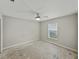 Spacious bedroom featuring neutral walls, a ceiling fan, and natural light from the window at 5522 1St Se St, Lakeland, FL 33812