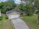 Exterior shot of a home with a brick driveway, well-manicured lawn, and two-car garage at 5522 1St Se St, Lakeland, FL 33812