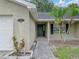 Close-up of front entrance with walkway and small palm trees enhancing curb appeal at 5522 1St Se St, Lakeland, FL 33812