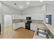 Kitchen with white cabinets, tan countertops, oven and microwave at 5522 1St Se St, Lakeland, FL 33812