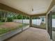 Covered and enclosed patio overlooking the backyard with a white fence and lush trees at 5522 1St Se St, Lakeland, FL 33812