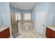 Bright bathroom featuring a soaking tub, step stool, glass shower, tile flooring, and dual vanities at 6217 Ashley Dr, Lakeland, FL 33813