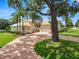 Charming home with a brick driveway, attached garage, mature trees, and lush landscaping at 6217 Ashley Dr, Lakeland, FL 33813