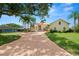 Spacious two-story home with a brick driveway, mature trees, and lush green lawn at 6217 Ashley Dr, Lakeland, FL 33813