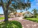 Beautiful home with a brick driveway, mature trees, and lush landscaping at 6217 Ashley Dr, Lakeland, FL 33813