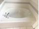 Close up photo of bathroom soaking tub with gray tiled trim and faucet at 624 Brockton Dr, Kissimmee, FL 34758
