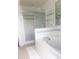 Bathroom featuring corner garden tub and standing shower with glass doors at 624 Brockton Dr, Kissimmee, FL 34758
