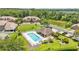Aerial view of a community pool and clubhouse surrounded by lush landscaping and homes with large grassy yards at 6365 Torrington Cir, Lakeland, FL 33811