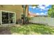Secluded backyard featuring lush green grass, a privacy fence, and sliding glass doors to the home at 6365 Torrington Cir, Lakeland, FL 33811