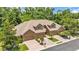 Exterior view of a townhome with three garage doors, dormer windows, and mature trees in the background at 6365 Torrington Cir, Lakeland, FL 33811