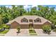 Exterior view of a residential building showing architectural details, a three-car garage, and tree-lined surroundings at 6365 Torrington Cir, Lakeland, FL 33811