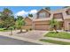 Inviting townhome with a brick driveway, attached garages, and mature palm trees at 6365 Torrington Cir, Lakeland, FL 33811